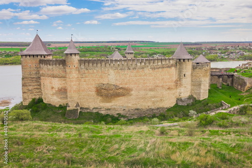 View of old castle Hotin near the river. Khotyn Fortress - medieval castle on yellow autumn hills. Ukraine, Eastern Europe. The architecture of the Middle Ages in our time.