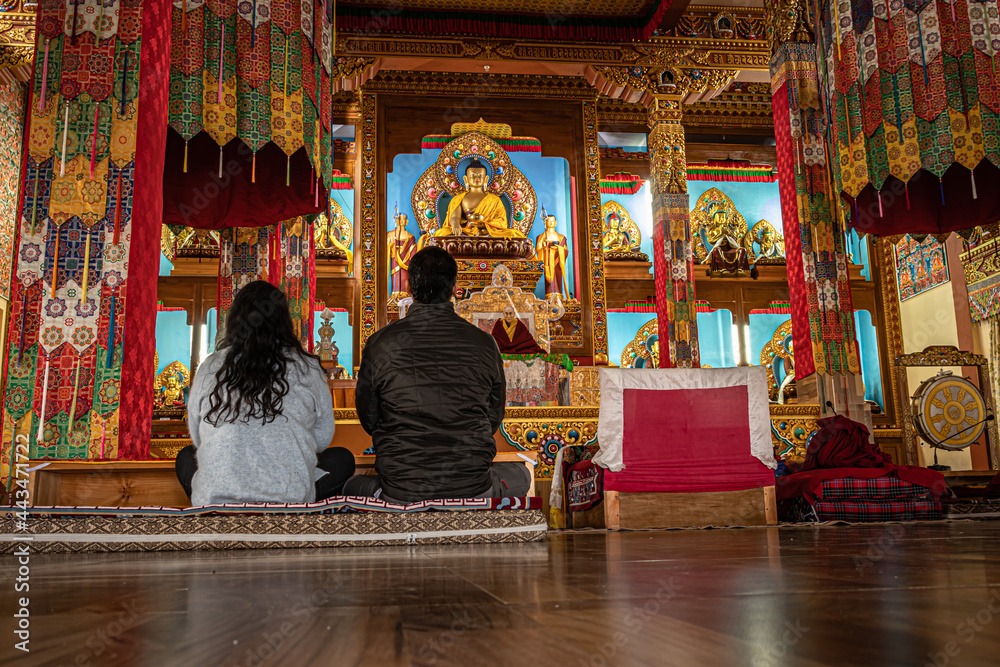 couple meditating isolated inside buddhist monastery at morning from low angle