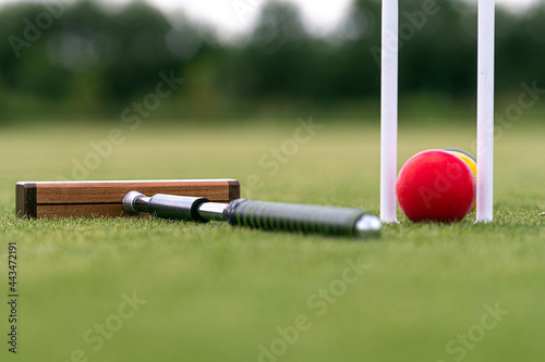 croquet mallet, wicket and colorful balls on a lawn photo