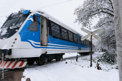 Tren diésel en movimiento en paso a nivel nevado. Tren en las sierras de Córdoba. Argentina 