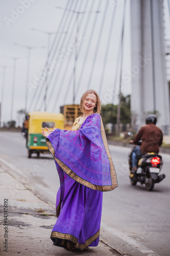 Young european woman with short hair in purple traditional saree. Outdoor portrait. India, Bangalore