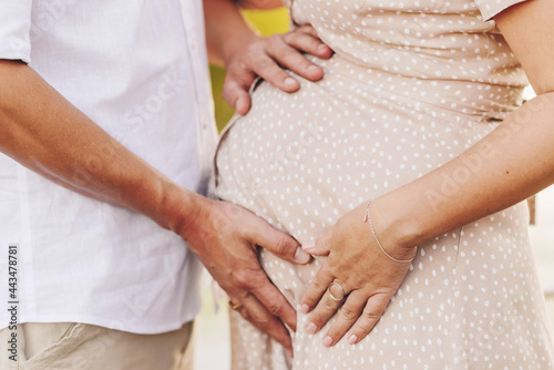 Happy couple pregnant woman and man are standing near the lake © Юлия Пельт