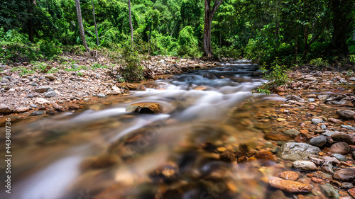 majestic deep waterfall flowing motion in rainforest with sunlight, panoramic wilderness and wet heaven freshness in the morning, hiking into the wild natural forest