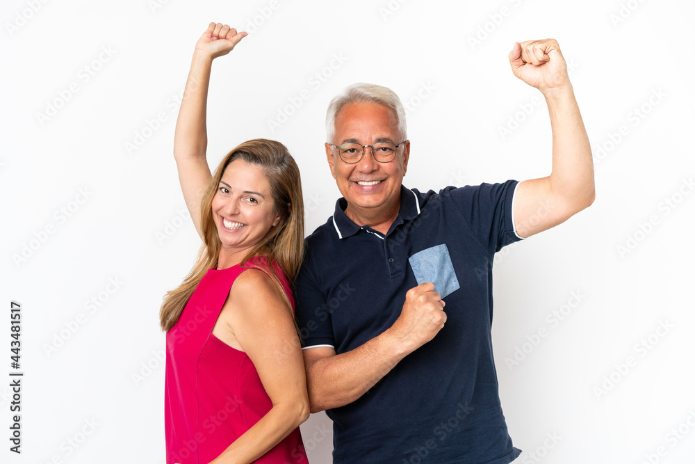 Middle age couple isolated on white background celebrating a victory Middle age couple isolated on white background celebrating a victory