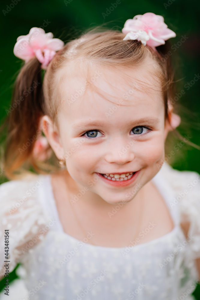 portrait of a cheerful little girl in a white dress.happy and carefree childhood portrait of a cheerful little girl in a white dress.happy and carefree childhood