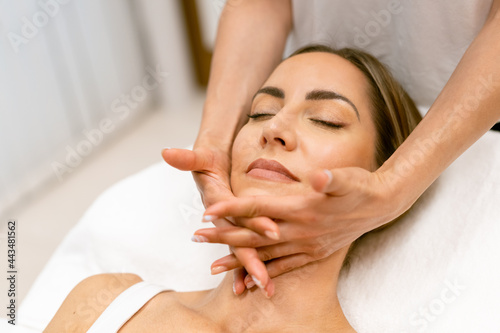 Middle-aged woman having a head massage in a beauty salon.