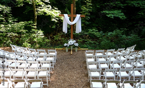 Canvas-taulu An outdoor setting of a wedding ceremony with white chairs, white flowers and wh