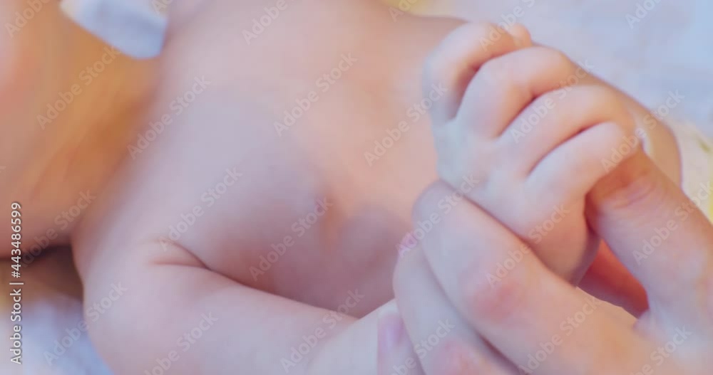 the hand of a small child is holding on to mom's finger.close-up. the hand of a small child is holding on to mom's finger.close-up.