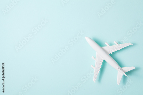 Flat lay design of travel concept with plane on light blue background.