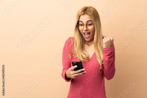 Young Uruguayan blonde woman over isolated background surprised and sending a message