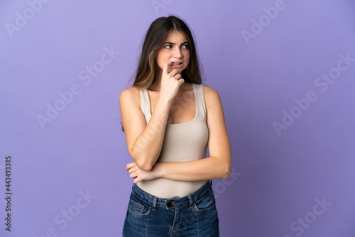 Young caucasian woman isolated on purple background nervous and scared