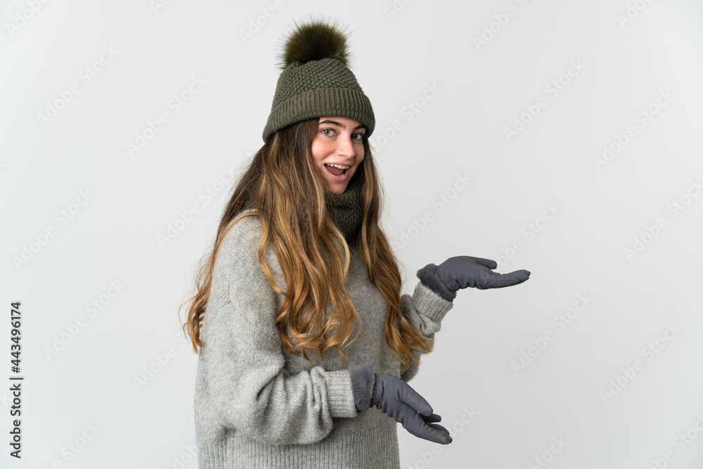 Young caucasian woman with winter hat isolated on white background with surprise expression while looking side Young caucasian woman with winter hat isolated on white background with surprise expression while looking side