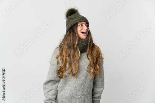 Young caucasian woman with winter hat isolated on white background laughing