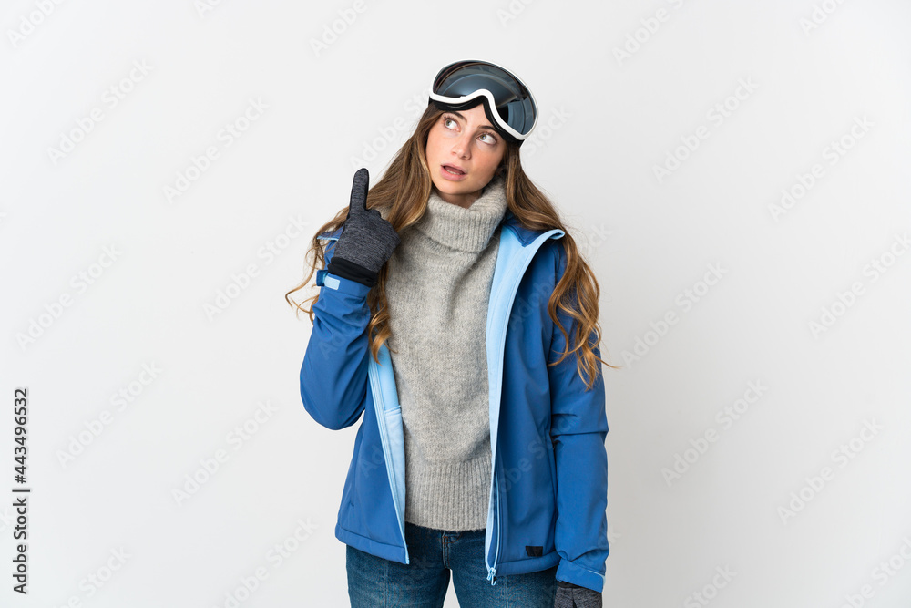 Skier girl with snowboarding glasses isolated on white background thinking an idea pointing the finger up Skier girl with snowboarding glasses isolated on white background thinking an idea pointing the finger up
