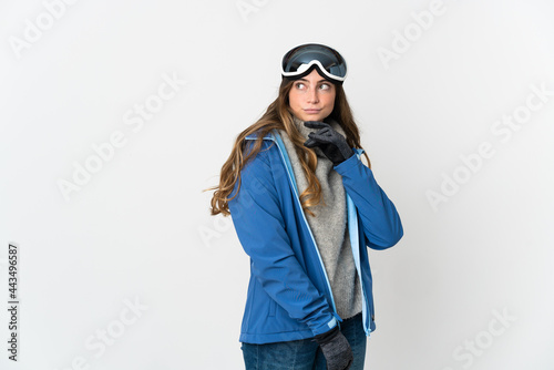Skier girl with snowboarding glasses isolated on white background and looking up