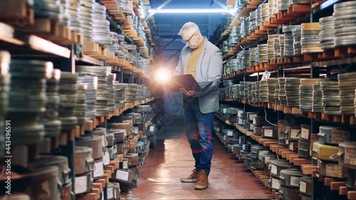 Male archivist is keeping the record of vintage film tapes photo