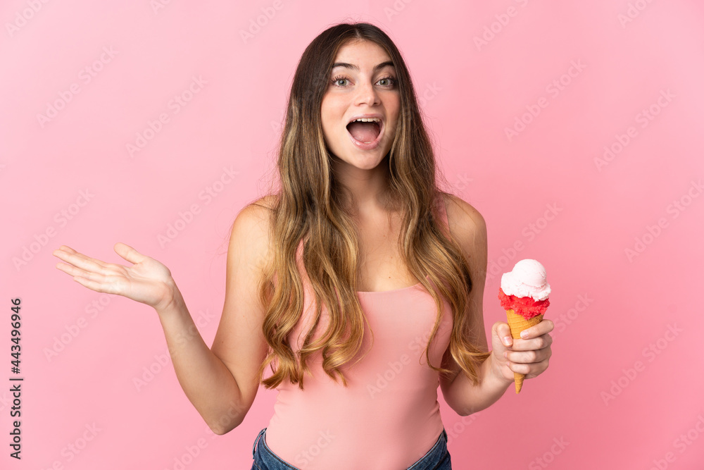 Young caucasian woman with a cornet ice cream isolated on pink background with shocked facial expression Young caucasian woman with a cornet ice cream isolated on pink background with shocked facial expression