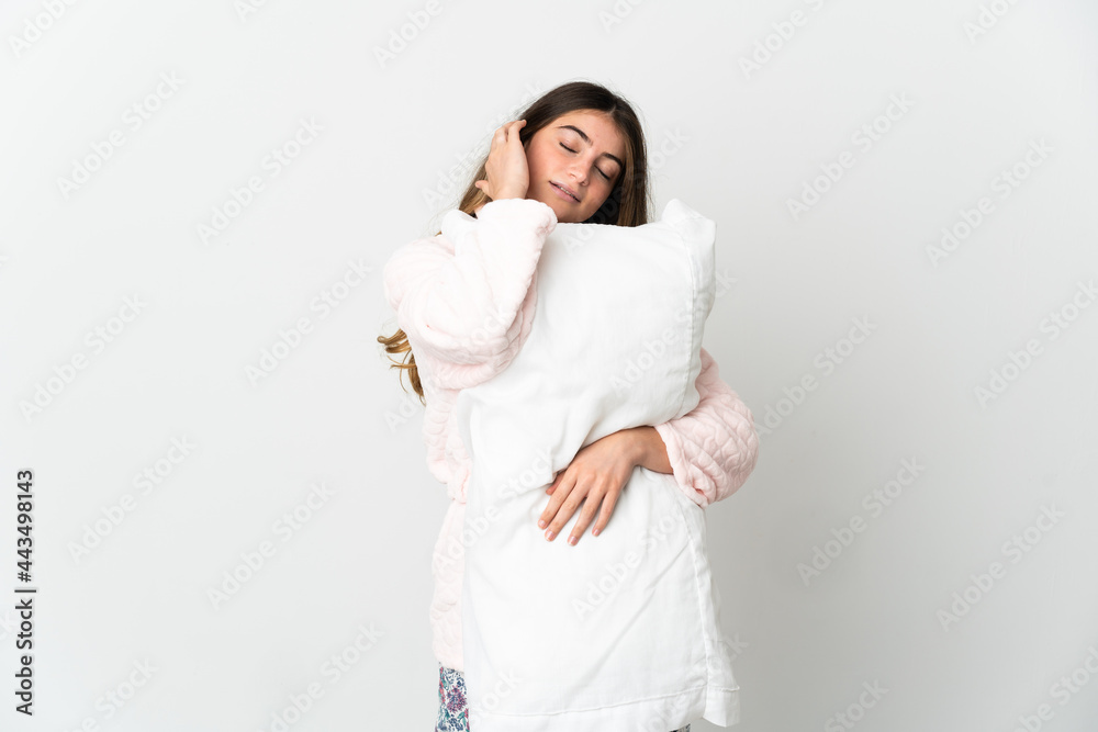 Young caucasian woman isolated on white background in pajamas and holding a pillow while sleeping Young caucasian woman isolated on white background in pajamas and holding a pillow while sleeping