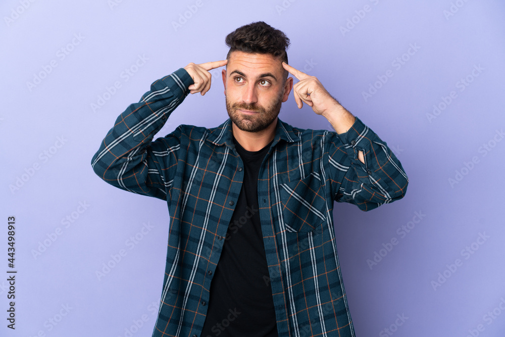 Caucasian man isolated on purple background having doubts and thinking Caucasian man isolated on purple background having doubts and thinking