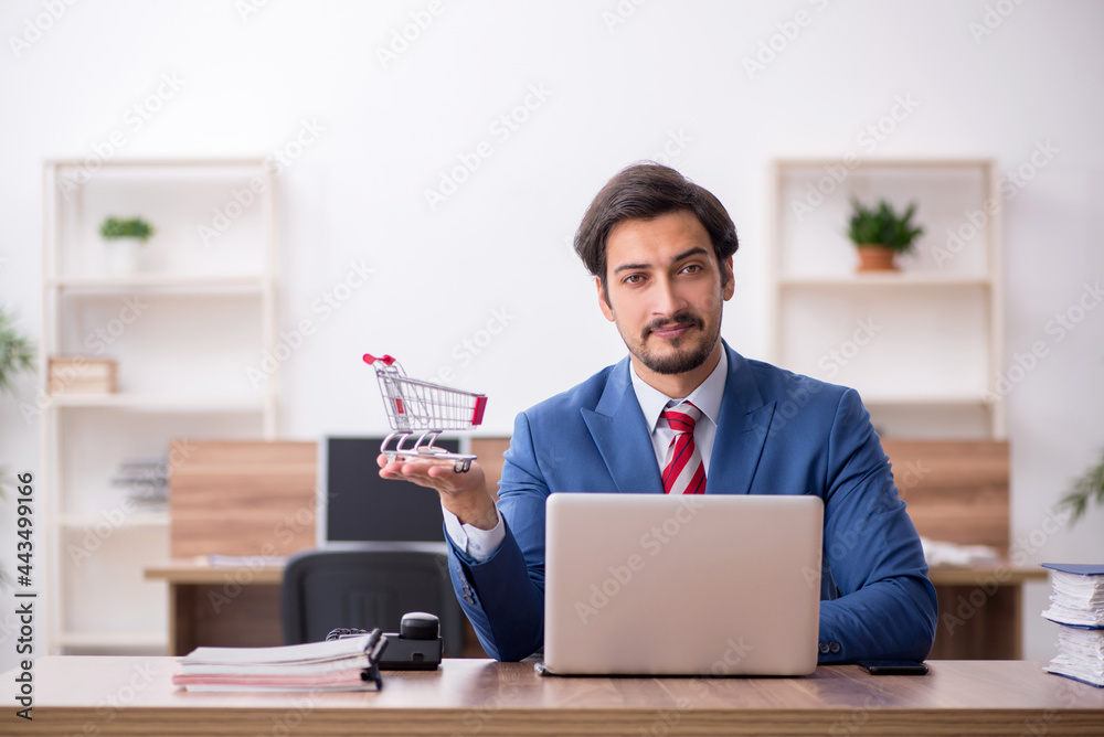 Fototapeta premium Young male employee in e-commerce concept at workplace