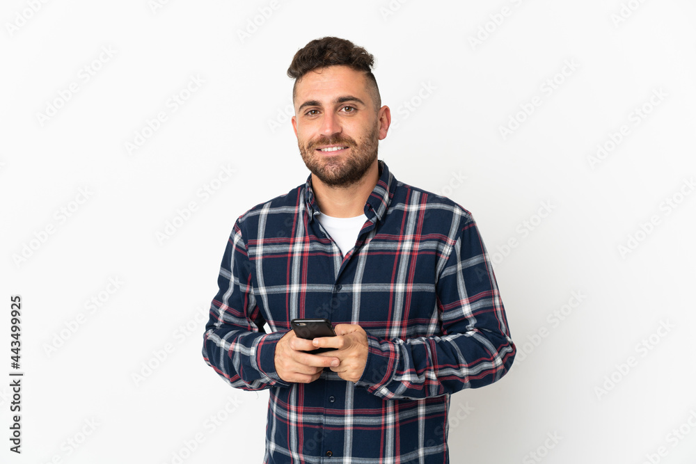 Caucasian man isolated on white background sending a message with the mobile Caucasian man isolated on white background sending a message with the mobile