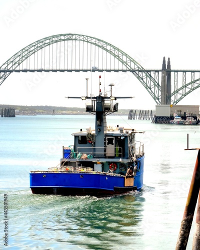 Yaquina Bay bridge with Blue fishing boat photo