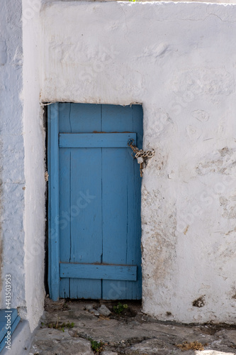 Petunia flowers in a yellow pot on a blue window sill, Cyclades Greece.