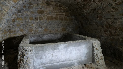 Rough grinding  stone freezer in an old cragged basement made of red bricks in Ukraine 