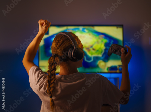 Shooter, a young woman plays an online game, entertainment, passion for modern computer technologies. The woman reacts emotionally to the course of the game. Relaxation.