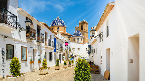 Street of Altea old town in Spain. Beautiful village with white houses and blue domed church Our Lady of Solace. Popular Spanish tourist destination, Costa Blanca region photo