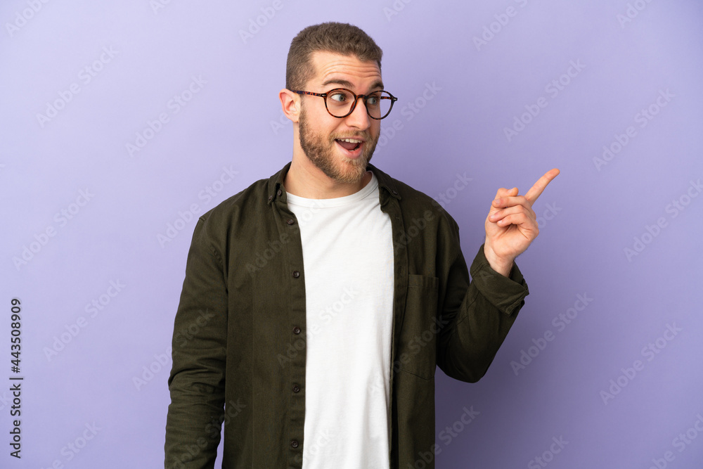 Young handsome caucasian man isolated on purple background intending to realizes the solution while lifting a finger up Young handsome caucasian man isolated on purple background intending to realizes the solution while lifting a finger up