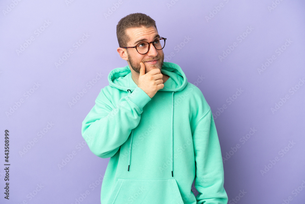 Young handsome caucasian man isolated on purple background thinking an idea while looking up Young handsome caucasian man isolated on purple background thinking an idea while looking up