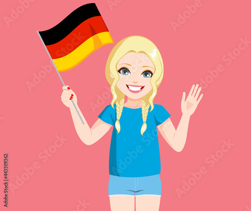 Beautiful young blonde german woman holding Germany flag and waving hand on pink background