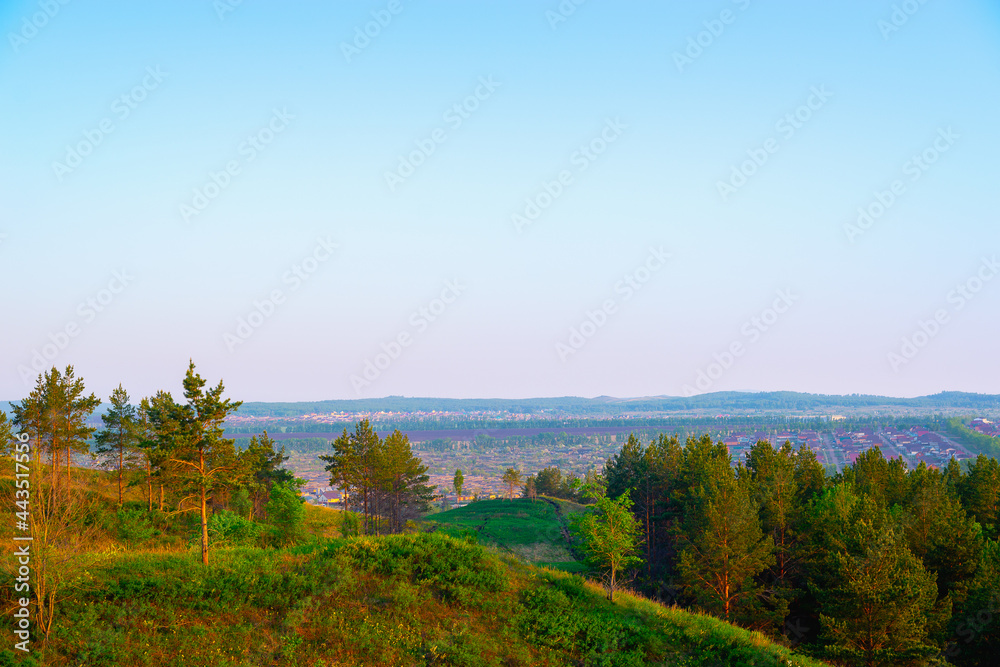 The hills are green and the village is visible in front.