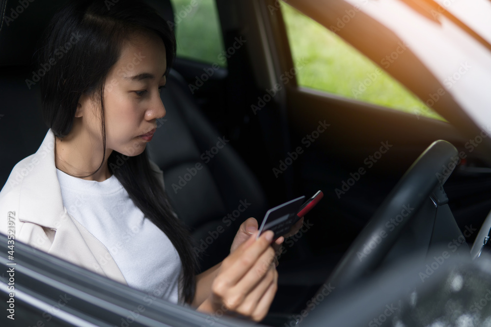 business woman using smartphone and credit card for shopping online in the car. Business new normal concept after covid-19 coronavirus outbreak.