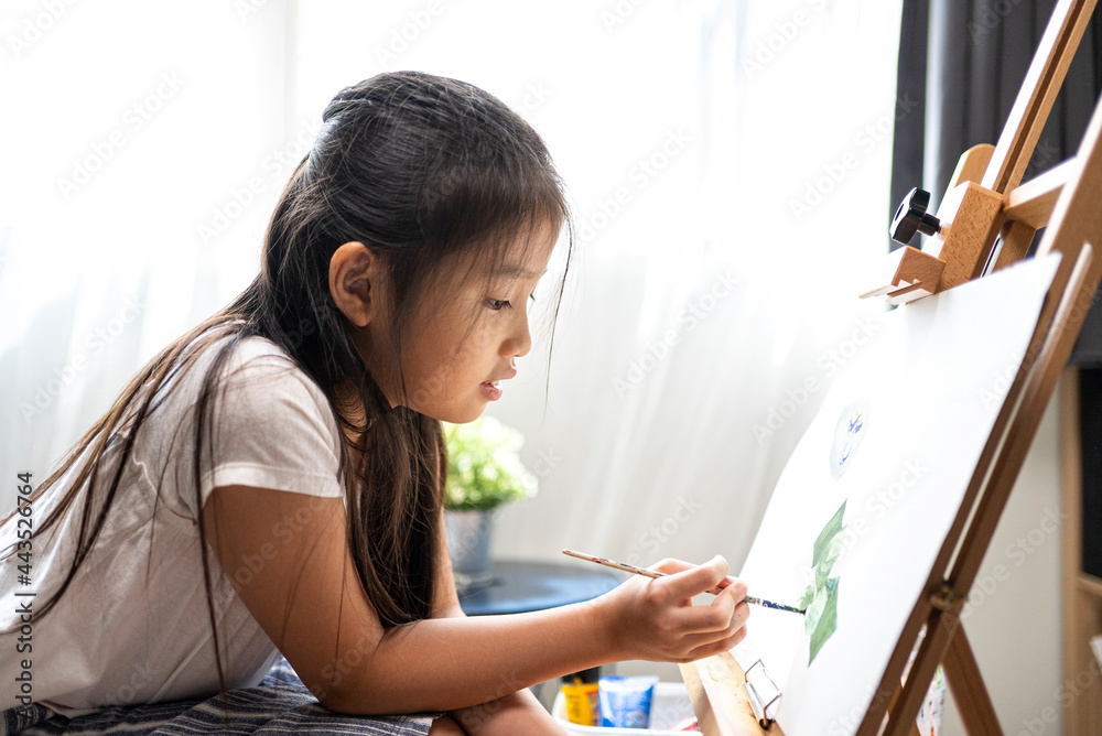 Asian beautiful girl with brush nd palette painting water color to canvas on wooden easel at home for her relaxing time. Asian beautiful girl with brush nd palette painting water color to canvas on wooden easel at home for her relaxing time.