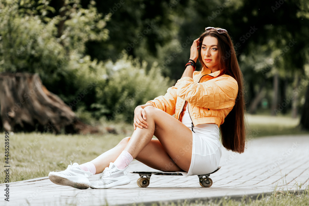 Beautiful and fashion young woman posing with skateboard. Sport activity lifestyle concept