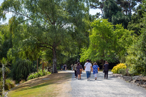 People enjoy walking through a city park on a summer day in Christchurch, New Zealand