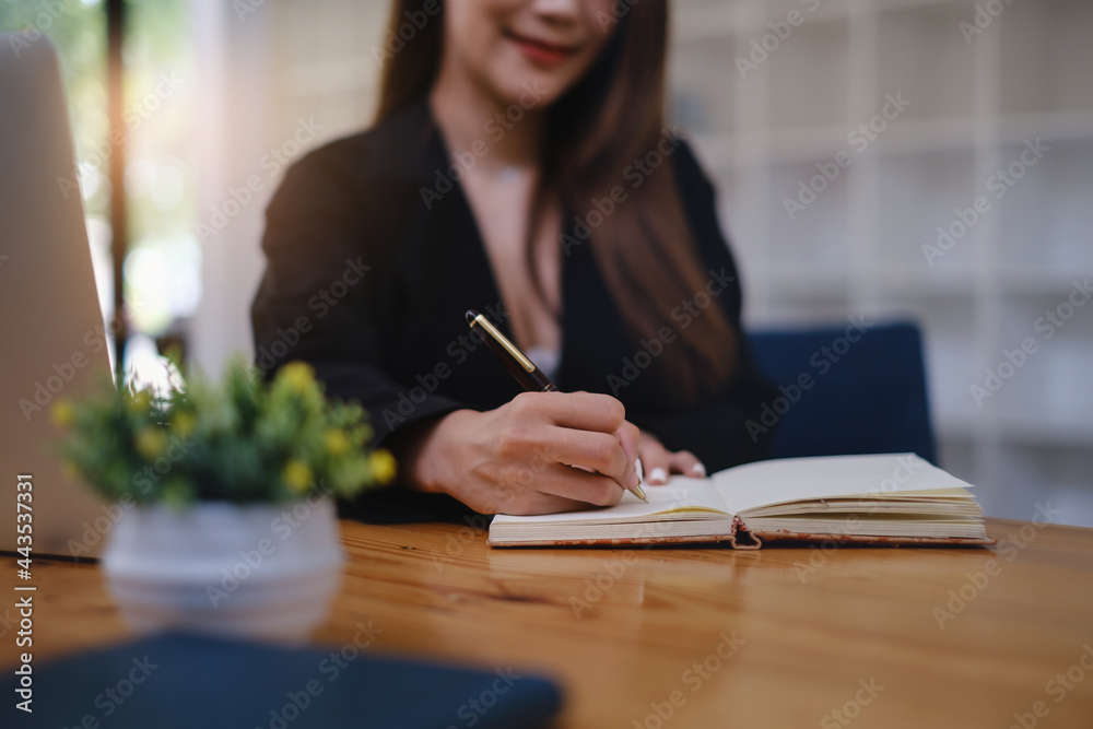 A woman studying webinar by laptop computer and taking note. A woman studying webinar by laptop computer and taking note.