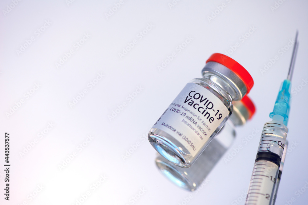 Ampoules with COVID-19 coronavirus vaccine, with a syringe for vaccination. Ampoules with COVID-19 coronavirus vaccine, with a syringe for vaccination.