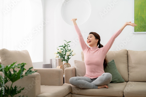 young woman feel carefree and stretch arm to take a deep breath at home