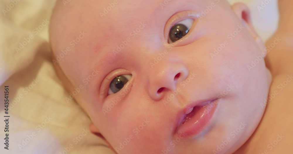 portrait of a small cute funny child who lies in his bed and looks up with surprise. close-up. portrait of a small cute funny child who lies in his bed and looks up with surprise. close-up.