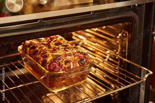 Ready cherry pie, clafoutis in baking dish in the oven