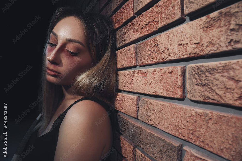 Fototapeta premium Overdosed drug addicted woman near brick wall. Space for text