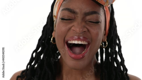 Closeup of african woman face. Yawning to the camera, tiredly. Isolated on a white background.