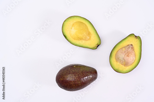 Top view whole and half avocado with seed on white background.