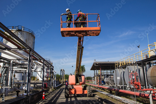 Two male  industry working at high in a boom lift