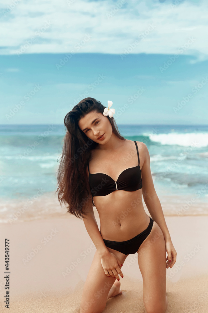 Portrait of pretty beautiful fashion woman in black bikini posing in summer near the sea and blue sky. Young Girl with tanned sexy body in swimwear with copy space. Summer lifestyle. Vacation Portrait of pretty beautiful fashion woman in black bikini posing in summer near the sea and blue sky. Young Girl with tanned sexy body in swimwear with copy space. Summer lifestyle. Vacation