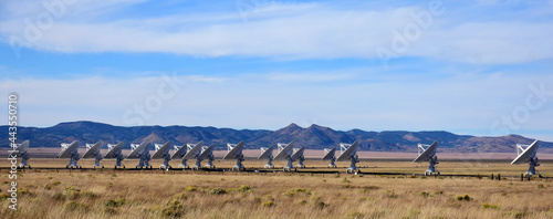 seventeen radio telescopes and giant dish antennas  in the karl g. jansky very large array radio astronomy observatory against a mountain backdrop  near socorro, new mexico 