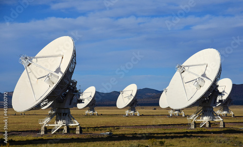seven radio telescopes and giant dish antennas  in the karl g. jansky very large array radio astronomy observatory against a mountain backdrop  near socorro, new mexico 